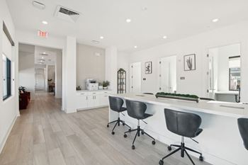 a white office with a long counter and chairs at The Maddox Luxury Apartment Homes, Buckeye, Arizona
